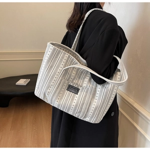 Détail d'un grand sac cabas en toile rayée avec étiquette tendance sur le sac à bandoulière