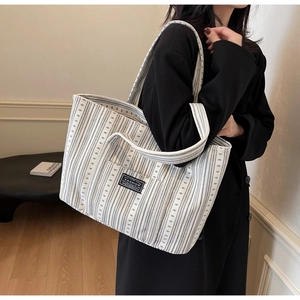 Détail du sac cabas grande capacité avec rayures géométriques noires et blanches et étiquette