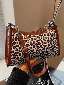 Borsa baguette retrò con stampa leopardata e finiture in pelle marrone in una scena a mano