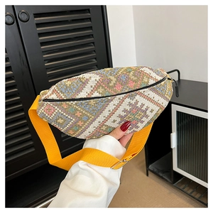 Détail d'un sac banane bohème tissé avec motifs géométriques et bandoulière jaune