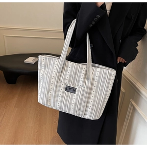Détail du grand sac cabas en toile rayée avec étiquette de mode sur le devant