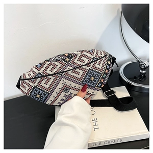 Détail du sac banane tissé aux motifs géométriques et bandoulière noire large