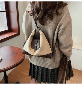 Detail of triangular color-block canvas and leather backpack with gold hardware