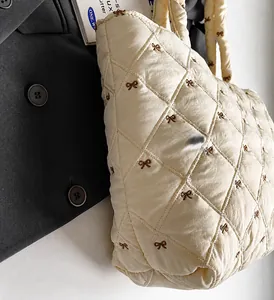 Gros plan du sac cabas matelassé crème avec broderie de nœuds pour le quotidien
