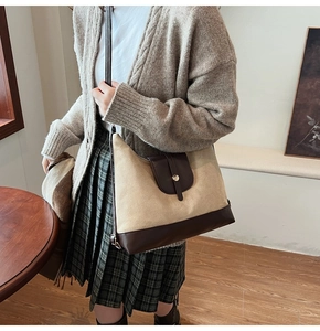 Detail of vintage canvas and brown leather tote bag worn with a plaid skirt outfit
