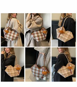 Detail of checkered tote bag showing textured tweed fabric and brown leather straps