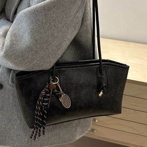 Large black tote bag in matte suede leather with decorative tassel and metal charm