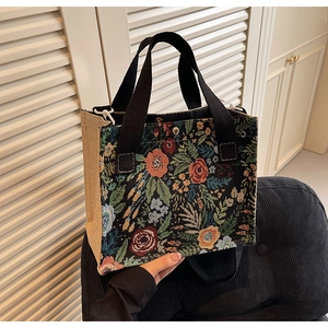 Detail of floral tapestry tote with reinforced metal base and woven handle grip