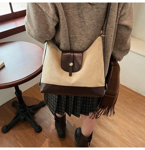 Detail of a beige and brown large capacity tote bag with elegant metal buckle closure