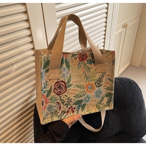 Close-up of floral jacquard woven handbag texture with khaki straps and detailed embroidery