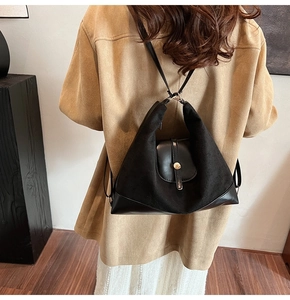 Detail of black leather and suede convertible tote bag worn as a backpack