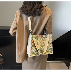 Detail of floral tapestry handbag featuring woven texture and adjustable beige strap