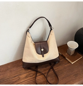 Detail of vintage beige canvas tote bag with dark brown leather trim and golden clasp
