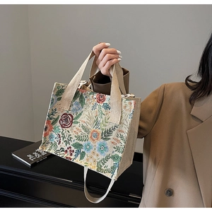 Detail of vintage floral tapestry handbag with rose embroidery and wide woven strap