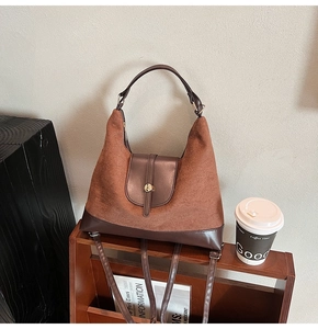 Detail of vintage brown suede tote bag showing metallic buckles and dual material texture