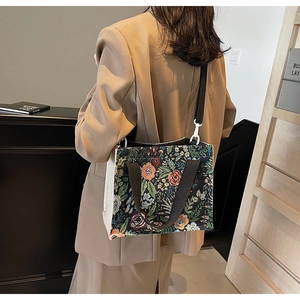 Close-up of floral tapestry woven tote bag with black handles and shoulder strap detail