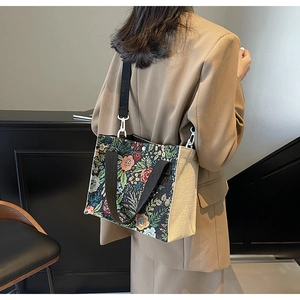 Floral jacquard tote bag with detachable shoulder strap shown on a model side view