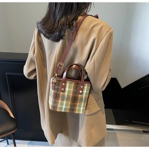 Detailed back view of a plaid wool mini tote bag with brown leather and gold rivets