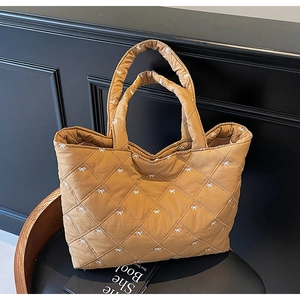 Close-up of khaki quilted tote bag with rhombus pattern and white bow embroidery