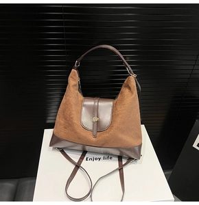 Detail of dark brown suede tote with smooth leather trim and vintage gold metal buckle