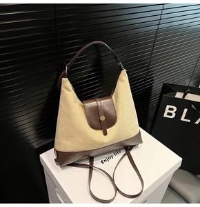 Detail view of large vintage canvas tote bag with brown leather trim on display