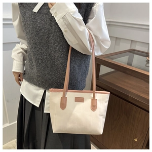 Detail of the minimalist tote bag featuring cream canvas and pink leather contrast trim