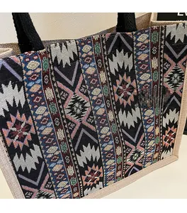Close-up of linen tote bag with ethnic geometric pattern and woven black handles