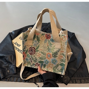 Detailed view of floral linen woven crossbody bag with canvas handle and shoulder strap
