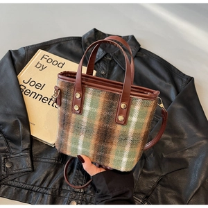 Detail of wool tote bag with plaid pattern on black leather jacket with a book