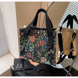 Floral tapestry tote bag detail with wide black strap and beige linen side panel
