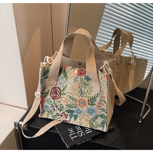 Detail of vintage floral jacquard pattern and canvas strap on a medium tote bag