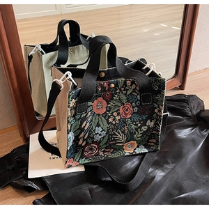Detail of floral tapestry tote with canvas side panel and detachable shoulder strap