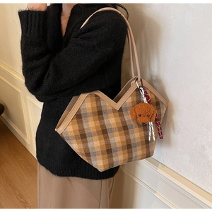 Detail view of large plaid tote bag with V-shaped neckline and cute puppy pendant