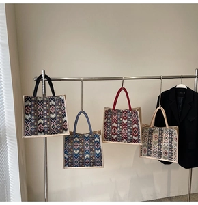 Close-up of four woven tote bags with geometric patterns and multi-color handles