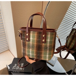 Detailed shot of plaid wool fabric texture and leather handle on a bucket bag