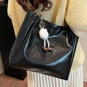 Retro black tote bag in glossy faux leather with plush pendant for autumn winter commute