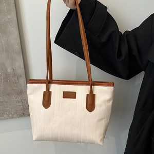 Minimalist beige tote bag with brown leather trim and large capacity for daily commuting