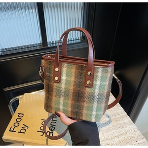 Detail of wool tote bag with vintage plaid pattern and brown leather trim detailing
