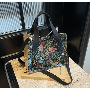 Detailed close-up of a floral embroidered linen tote bag on artistic books