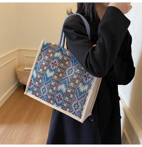 Detail of a large linen tote bag showing ethnic geometric patterns and blue rope handle