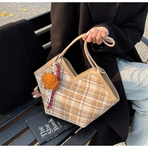 Retro plaid tote bag in brown and beige tweed featuring a plush puppy charm on a bench