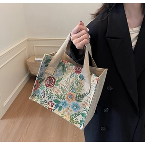 Close-up of vintage floral tapestry tote bag with vibrant rose and leaf woven pattern