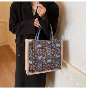 Detail of woven linen tote bag with geometric ethnic pattern and blue circular handles