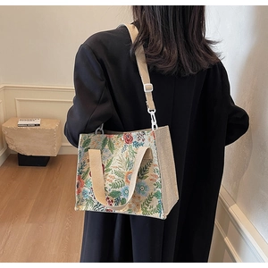 Detail of floral woven tote bag with jacquard pattern and adjustable cream shoulder strap