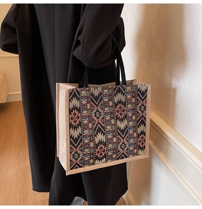 Detail of woven tote bag with tribal geometric patterns and sturdy black handles