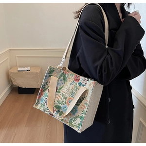 Detail of floral tapestry linen tote bag showing detachable brown shoulder strap and texture