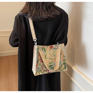 Detailed macro view of a vintage floral jacquard tote bag with wide webbing handle
