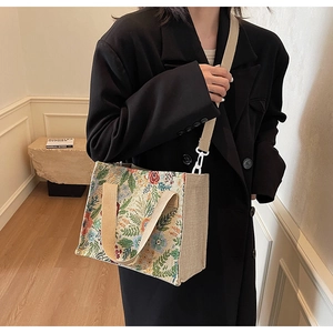 Detail of floral linen tote showing textured weave fabric and adjustable shoulder strap