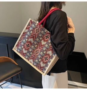 Detail of red rope handle and geometric woven pattern on large linen tote bag