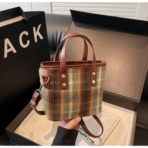 Premium wool plaid bucket bag with brown leather straps inside a luxury gift box